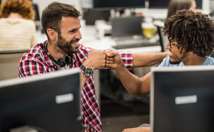 Two men fist bump showing company culture