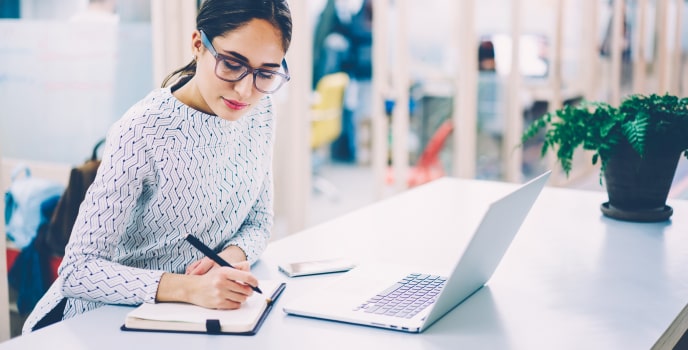 A woman taking notes on custom software development branding