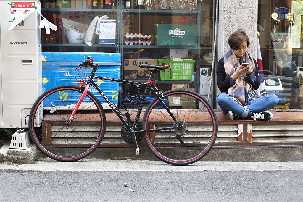 A rider relaxes outside a Seoul bar. 