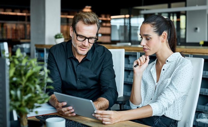 a man and a woman looking at design ideas on a computer