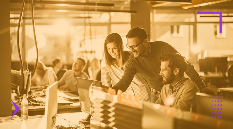 People in an open-space office looking at the desktop screen to represent a digital agency team