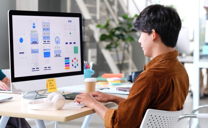 A web designer looking at different designs on their computer